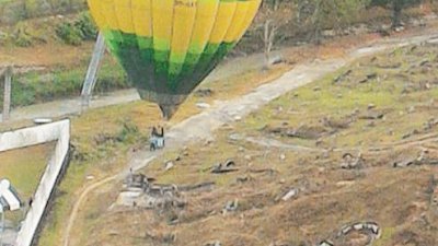 其中一个热气球周五早上随著风向飞到发林区后，安全降落在坟场路旁，并非发生意外。（图取自发林社警面子书）