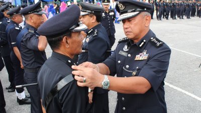 哈斯南（右）为升职的警员别上肩章。