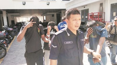 4名被告被警方押往槟城法庭时，全程掩面躲避镜头。
