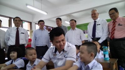 张盛闻（前排右2）到芙蓉新华小学巡视开课情况，与小一新生愉快聊天。