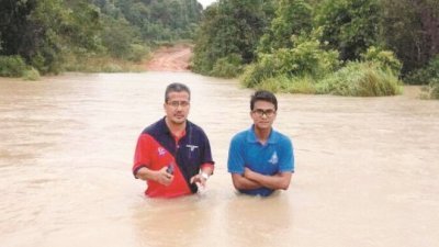 两名埔南国小教师，在水中前往学校了解情况。