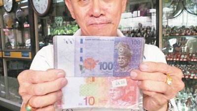 黄涌翔出示近日收到的100令吉假钞（上方）和一、两年前收到的10令吉假钞，促商家警惕。