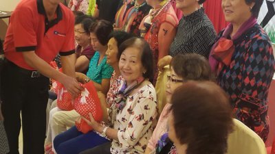 马华许汉宏（左）在一项活动中赠送礼品给乐龄妇女。