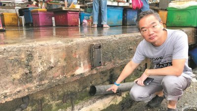 邱培栋在查看峇株安南批发公市C座建筑，已断裂超过10天的水管，而水管破裂也导致鱼贩无水可用。