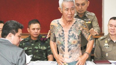 74岁的日本黑帮分子白井（中）周四被泰国警方拘捕。他被指涉及一宗15年的帮派谋杀案。