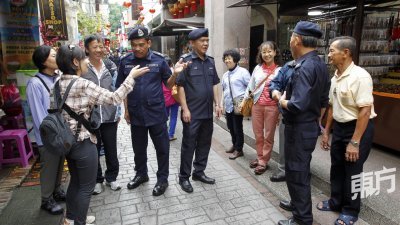 阿都法达（左4）与警员到旧街场二奶巷进行高调警政时，与一群台湾游客进行交流，左5是林金福。（摄影：李家俊）