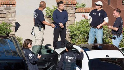 加利福尼亚州联邦特工警员在突击搜查其中一处月子中心时，向一名疑似经营者的亚裔男子问话。