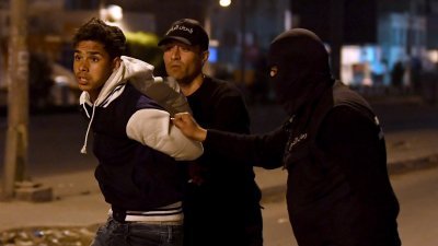 突尼斯因采取经济紧缩措施，引起民众不满，演变成骚乱，图为保安人员在突尼斯郊外的伊塔哈曼逮捕一名示威者。