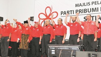 马哈迪（左6起）、慕尤丁及慕克里兹为土团党斯迪亚旺沙区部开幕，与区部领袖振臂高喊口号。-陈为康-