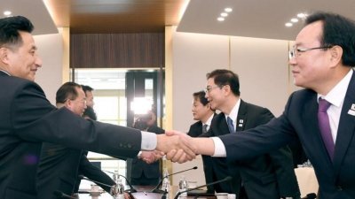 韩朝代表在会谈场所握手。