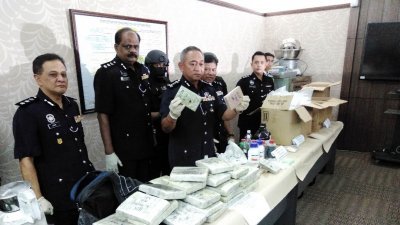 霹州及武吉安曼肃毒组联手侦破位于怡保九洞的炼毒室，起获总值约103万令吉的毒品及财物，左起是拉迪夫、拉威及哈斯南。