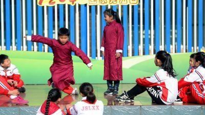 过去35年间，中国现行宪法经历了4次修改。图为去年12月4日，在石家庄市建胜路小学，学生们在表演以法律知识为主题的相声节目。