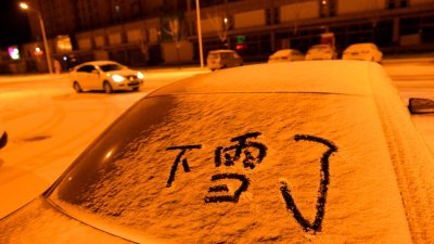 北京市、天津市及河北省在周日晚，终于迎来了初雪。河北省遵化市有民众在车后镜的积雪，写下“下雪了”，庆祝初雪到来。-新华社-