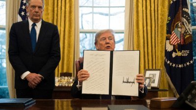 美国总统特朗普在美国贸易办公室代表莱蒂泽的陪同下，周二在白宫椭圆形办公室向传媒展示他签署的“201条款”法令。-法新社-