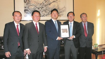 陈友信（右2）代表马中总商会赠送大马特色木雕刻纪念品给白天（左3）。左起为谢中正、卢国祥及郭隆生。