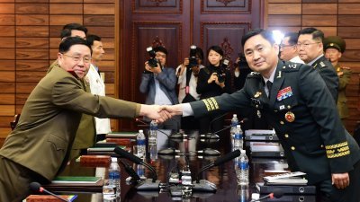 韩国代表团团长、国防部对朝鲜政策官金度均（右）与朝鲜代表团团长、陆军中将安益山握手，双方周四早在板门店朝方一侧的“统一阁”，举行时隔11年的韩朝将军级军事会谈。