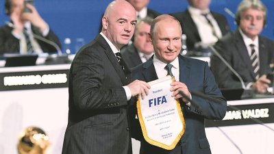 国际足联会长因凡蒂诺（左），周三在莫斯科举行的第68届国际足联大会上，向俄罗斯总统普京颁发纪念锦旗。