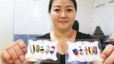 黄淑伶展示各种各样国家队国旗的指甲彩绘。