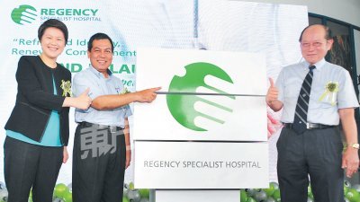 依斯迈（中）为立康专科医院推介新标志。陈玮 嘉（左）和郑炳辉（右）陪同。（摄影：杨金森）