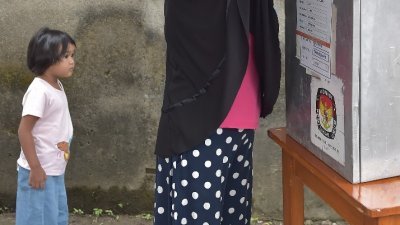 位于爪哇岛最西部的万丹省，丹格朗一名妇女在投票站投下手中神圣的一票。