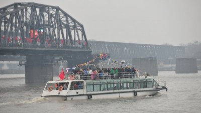 图为丹东游艇载满游客横渡鸦绿江，要去一览对岸的新义州风光。