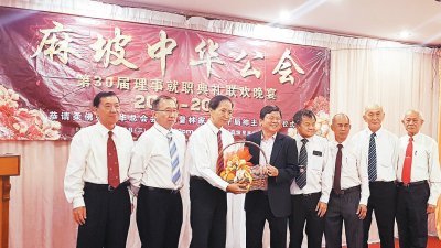 麻坡中华公会新届理事宣誓就职典礼晚宴上，该会主席林得元（左3起）赠送水果礼篮予林家全。