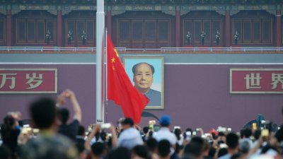 周日适逢中国共产党97周年党庆，一群观众在位于北京的天安门，观看该国国旗的升旗仪式。