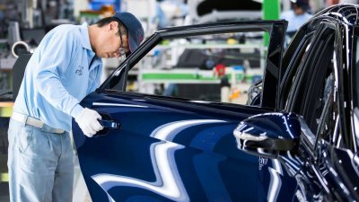 日本丰田汽车的车厂内，一名员工在检查一辆刚组装好的Mirai燃料电池车。