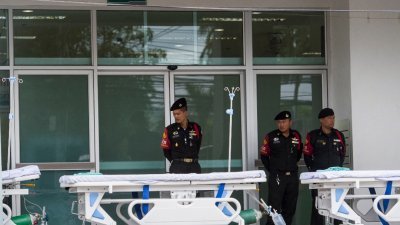 泰国政府准备了13支医护团队，分别对13个受困者进行一对一的医护照料。这是警方人员驻守于医院前，随时为救援行动待命。