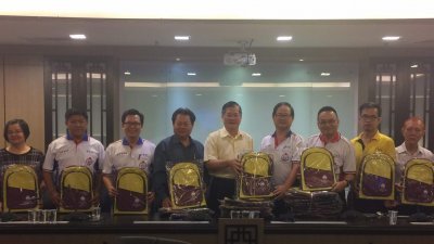 黄楚沅（左6起）、郑金财、杨利泉、陈鸿来分发书包给各国中华文学会教师作为教师节纪念品。