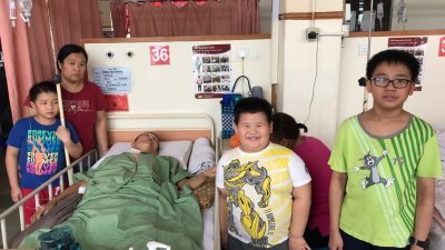 苏国良（躺者）因发烧于7月6日再次进院，冯美芳（左2）除了医院住家两地奔波，也要接送孩子上下学。