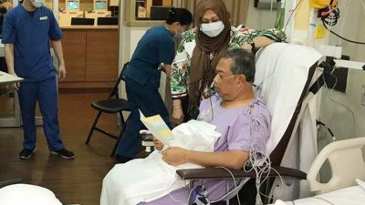 接受切除胰脏肿瘤手术后，目前在医院留医的慕尤丁（紫衣者）可坐著阅读。
