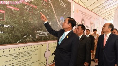 泰国首相巴育（左）去年12月在东北部呵叻府巴冲县，出席中泰铁路第一期工程的动工仪式，研究铁路的路线图。但相关铁路工程如今遭遇阻力。-新华社-