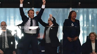 法国总统马克龙（左2）在法国队奠定胜局后，难以压抑内心狂喜，在贵宾看台前的平台上欢呼庆祝。