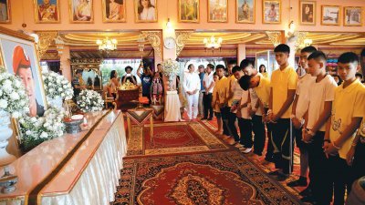 获救的少年足球队一行人，周四聚集在清莱府北部庙宇，悼念于此次洞穴救援行动中，意外丧生的泰国海军海豹部队前队员萨曼，并在他遗照前默哀。