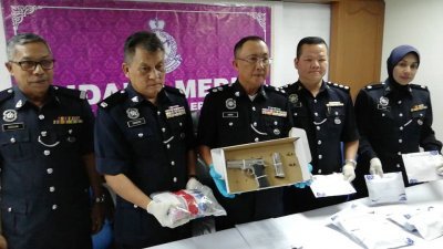 阿末峇迪（左3）向媒体展示警方起获的手枪等证物，左2起 是沙努西及陈木华。