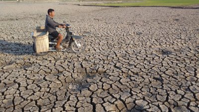 印尼中爪哇出现旱灾，沃诺吉里的一个水坝已乾枯，当地居民周六骑著摩哆，经过龟裂的土地。印尼中爪哇出现旱灾，沃诺吉里的一个水坝已乾枯，当地居民周六骑著摩哆，经过龟裂的土地。