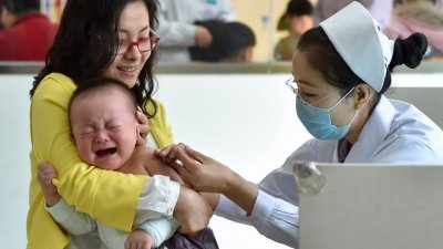 中国疫苗近年多次出事，引起舆论挞伐。这是天津市红桥区铃铛阁社区卫生服务中心的医护人员，在给儿童接种疫苗。