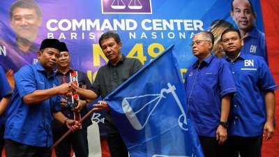 巫统署理主席拿督斯里莫哈末哈山（右3起）移交国阵旗帜予哥打拉惹区部主席拿督卡马鲁扎曼，象征式启动巫统双溪坎迪斯的竞选机器，右2为依斯迈沙比里。