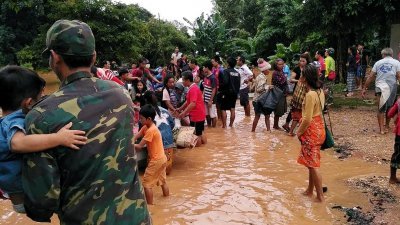 寮国当局派船到灾区，村民带著自己的家当，撤离被洪水淹没的家园。到灾区救援的士兵，抱著小孩登船。