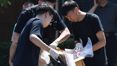 北京的美国大使馆外周四发生爆炸事件，安全人员事发后在现场查看证物。