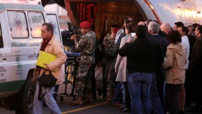 巴拉圭士兵从军机卸下罹难者遗体，准备送往医院。