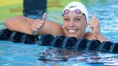 凯瑟琳-贝克在美国全国游泳锦标赛，以58秒00的成绩打破女子100公尺仰泳世界纪录后，举起两个姆指示意。