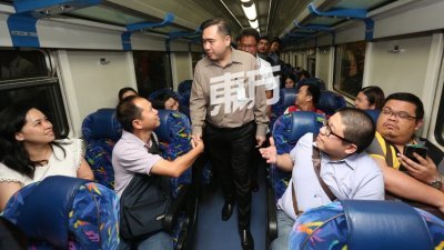 陆兆福在巡视地不佬直通车时，亲切地与通勤的乘客交流。（摄影：刘维杰）
