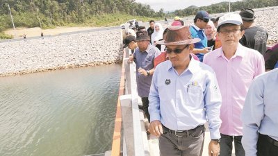 莫哈末嘉益士（前排左起）和陈信莱巡视将于8月竣工的加亨水坝输水管及给水泵站工程进展。