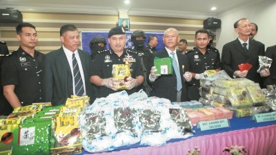 莫末沙烈（右3）向媒体展示警方所起获的百万令吉毒品；右为肃毒部副总监拿督江志坚。 （摄影：张真甄）