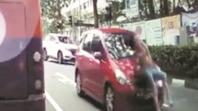 视频截图显示，妇女被撞后贴在汽车挡风镜上，汽车继续行驶。