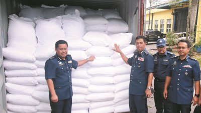 莫哈末哈密丹（左2）展示被充公的其中一个货柜装满走私米。