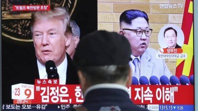 一名正在首尔地铁站的男士正在看有关美国总统特朗普将和朝鲜最高领导人金正恩会晤的电视新闻。