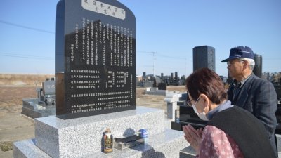东日本大地震7周年纪念，日本各地举行悼念活动。民众在宫城县岩沼市的纪念碑前，拜祭罹难的亲人。
